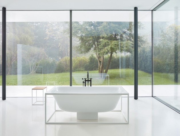 A stylish steel bath in the centre of a room with windows copy